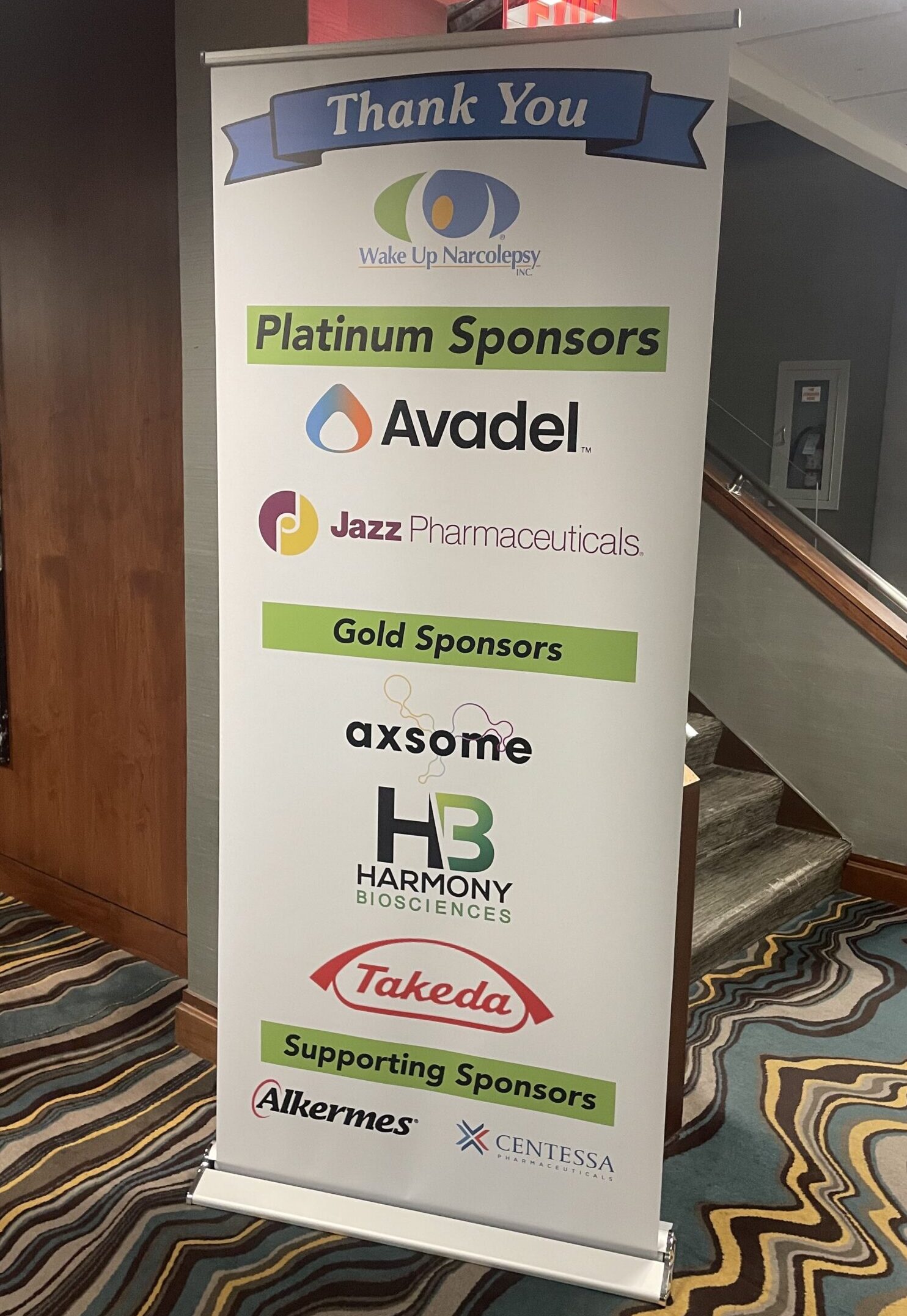 Sponsor Banner at 2023 Wake Up Narcolepsy National Conference & Patient Summit in Rochester, Minnesota - Platinum Sponsors - Avadel, Jazz Pharmaceuticals - Gold Sponsors - Axsome, Harmony Biosciences, Takeda - Supporting Sponsors - Alkermes, Centessa Pharmaceuticals