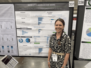 Woman standing smiling in front of research poster